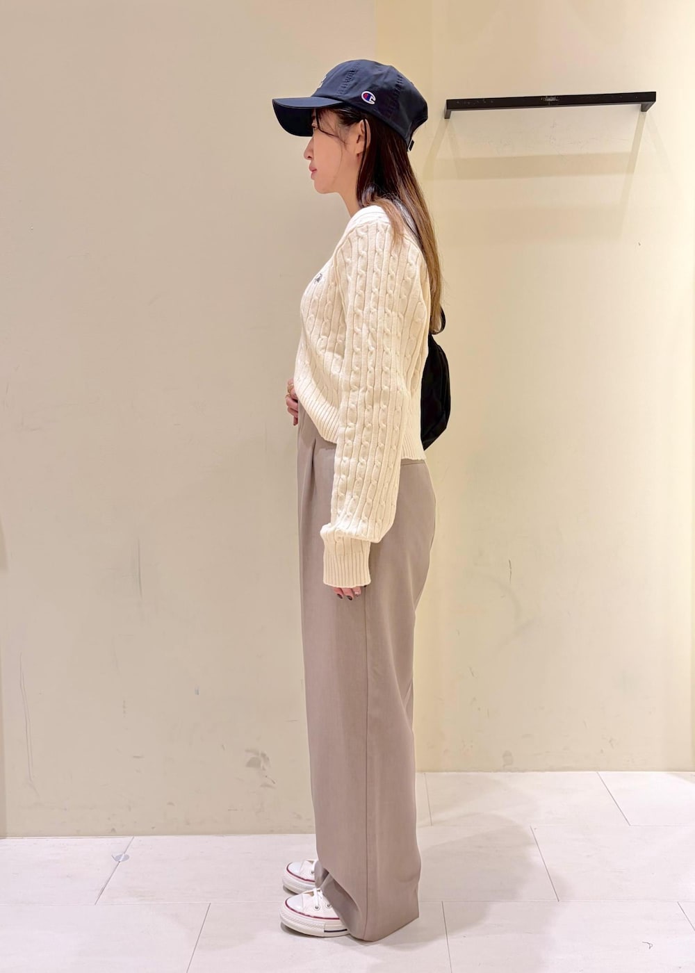 ホワイト系のニット/セーター、ベージュ系のその他パンツ、ブラック系のボディバッグ/ウエストポーチを着用したレディースの冬コーディネートの2枚目の写真