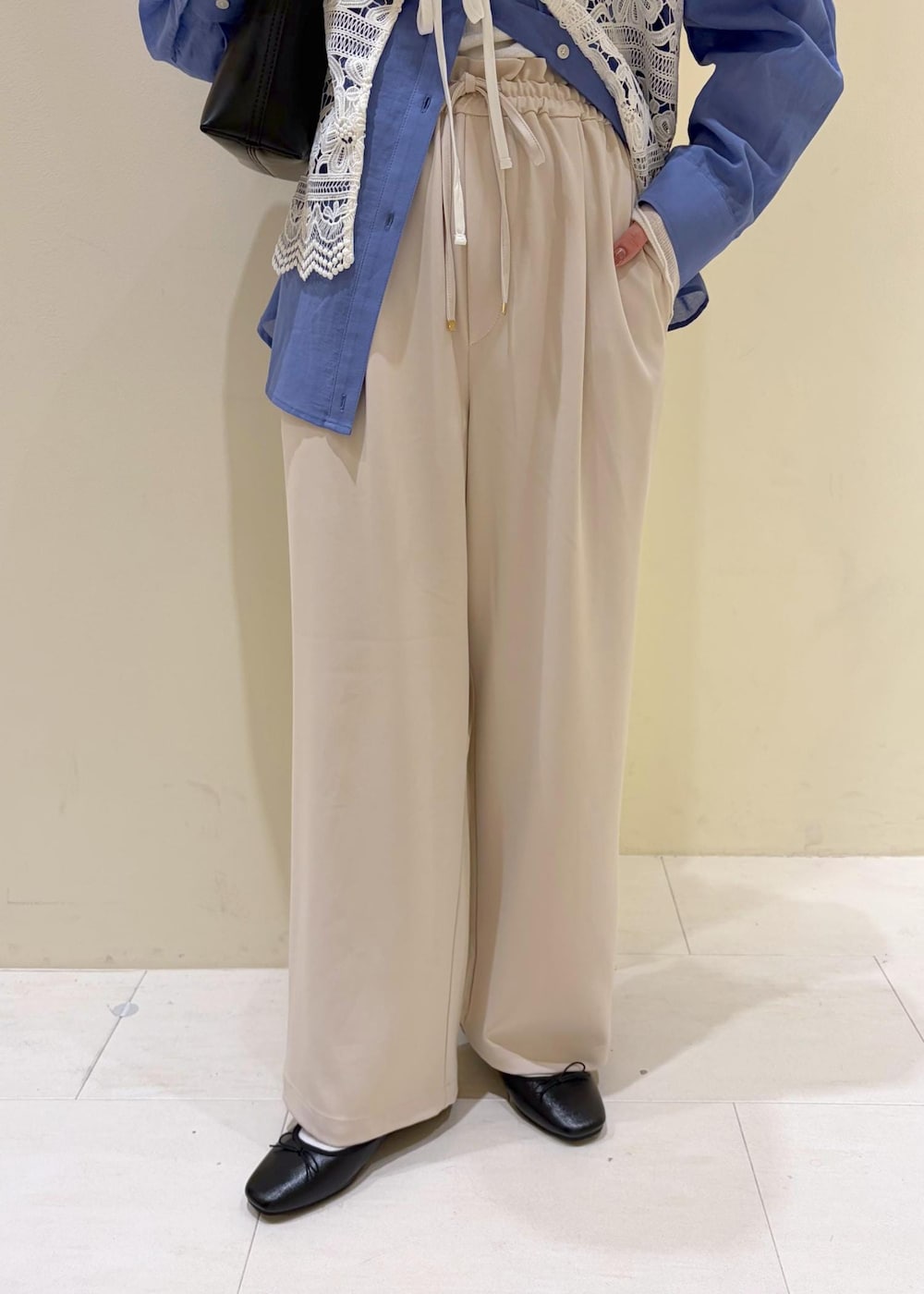 ブラック系のショルダーバッグ、ベージュ系のその他パンツ、ホワイト系のキャミソールを着用したレディースの春コーディネートの7枚目の写真