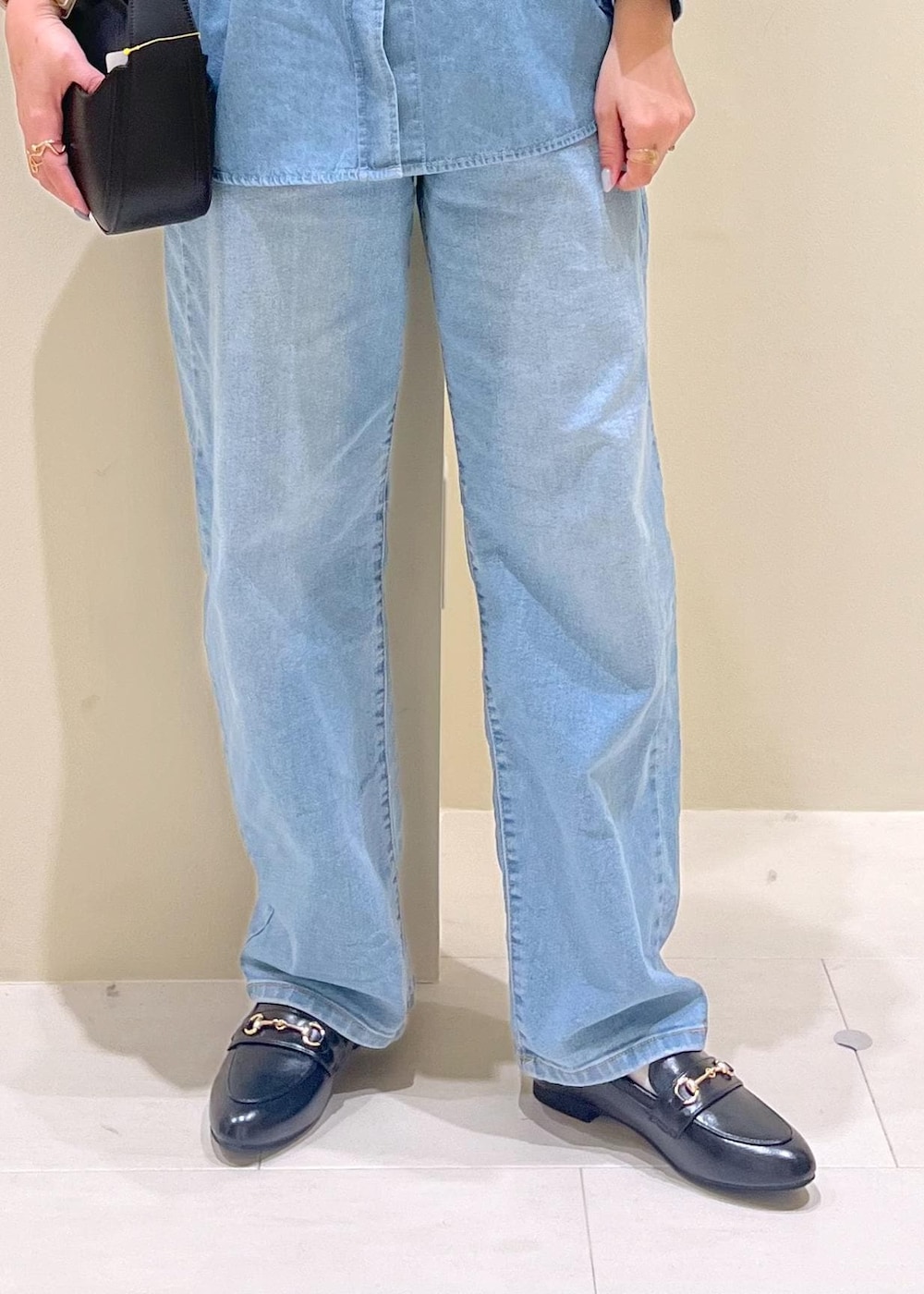 ブルー系のデニムパンツ、ホワイト系のキャミソール、ブラック系のハンドバッグを着用したレディースの春コーディネートの8枚目の写真