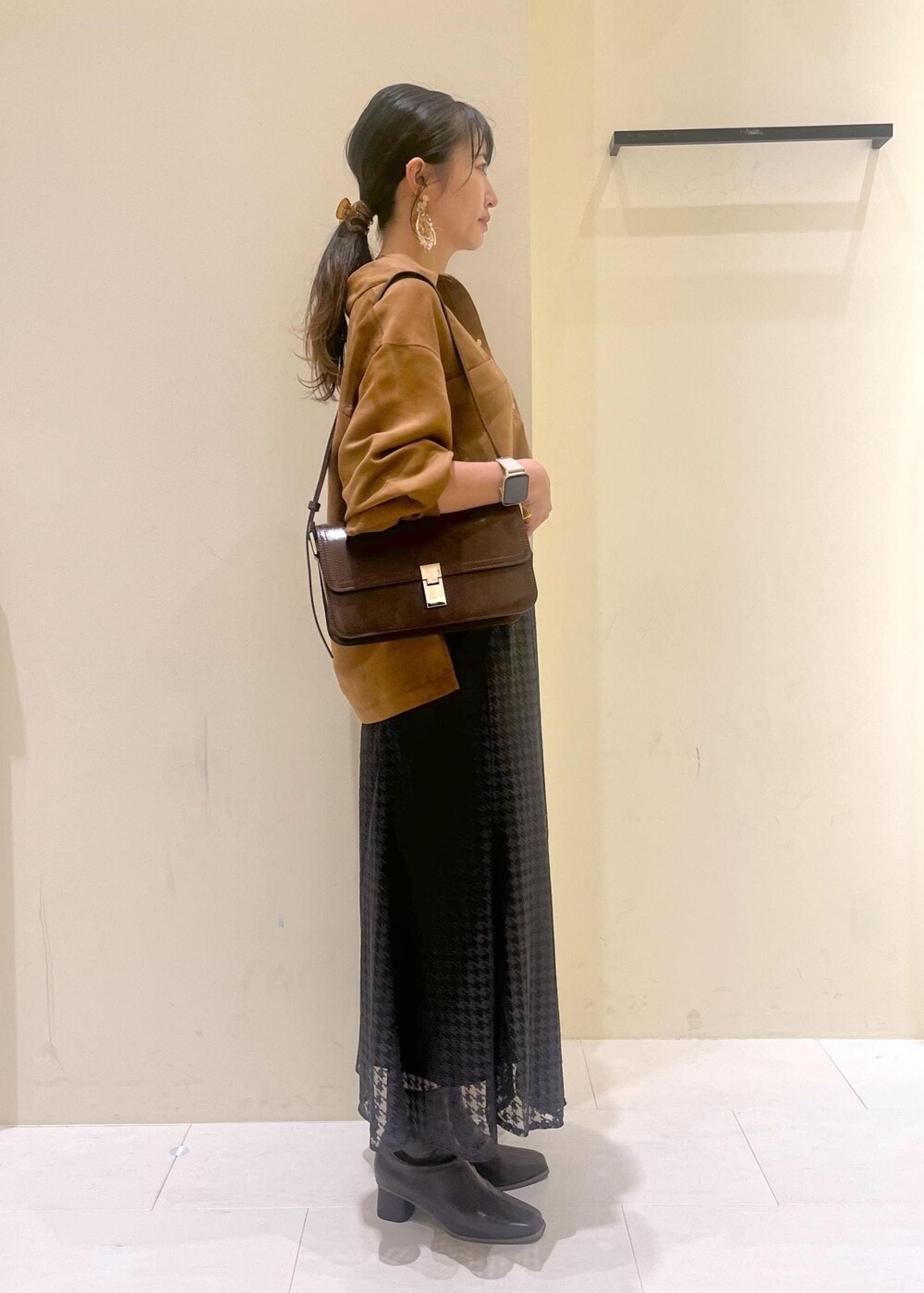 グレー系のタンクトップ、レッド系のショルダーバッグ、ブラウン系のシャツ/ブラウスを着用したレディースの秋コーディネートの2枚目の写真