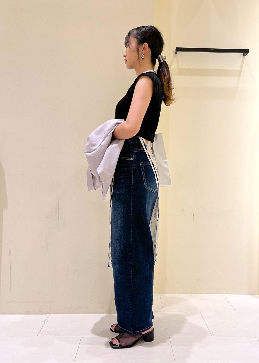 ブルー系のデニムパンツ、シルバー系のトートバッグ、ブラック系のパンプスを着用したレディースの夏コーディネートの4枚目の写真