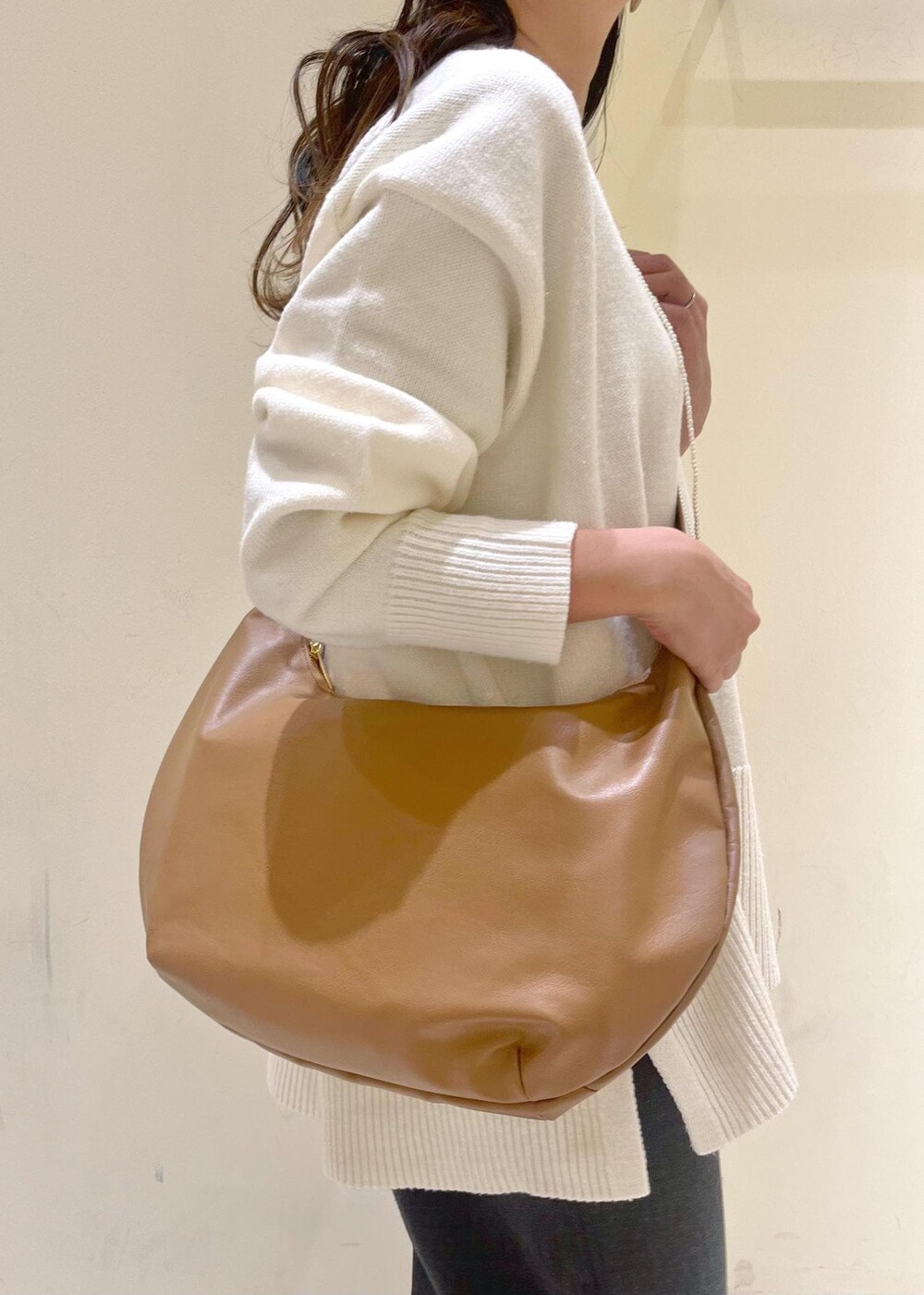 ホワイト系のニット/セーター、グレー系のスラックス、ブラウン系のローファーを着用したレディースの冬コーディネートの8枚目の写真