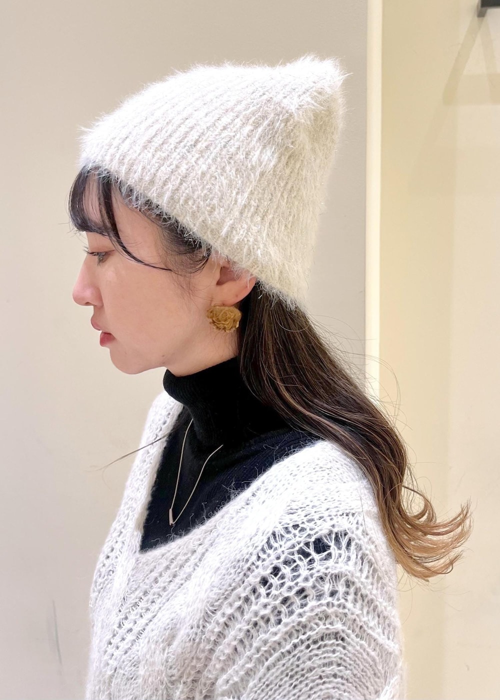 ブラック系のニット/セーター、ブラック系のブーツ、ブラウン系のショルダーバッグを着用したレディースの秋コーディネートの4枚目の写真