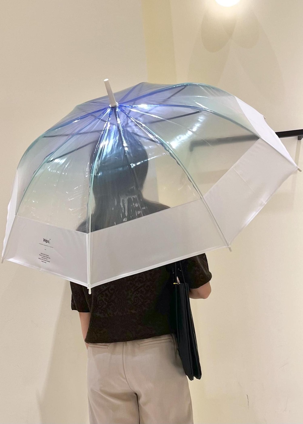 ブラック系のレインシューズ、ブラック系のトートバッグ、ベージュ系のその他パンツを着用したレディースの夏コーディネートの6枚目の写真