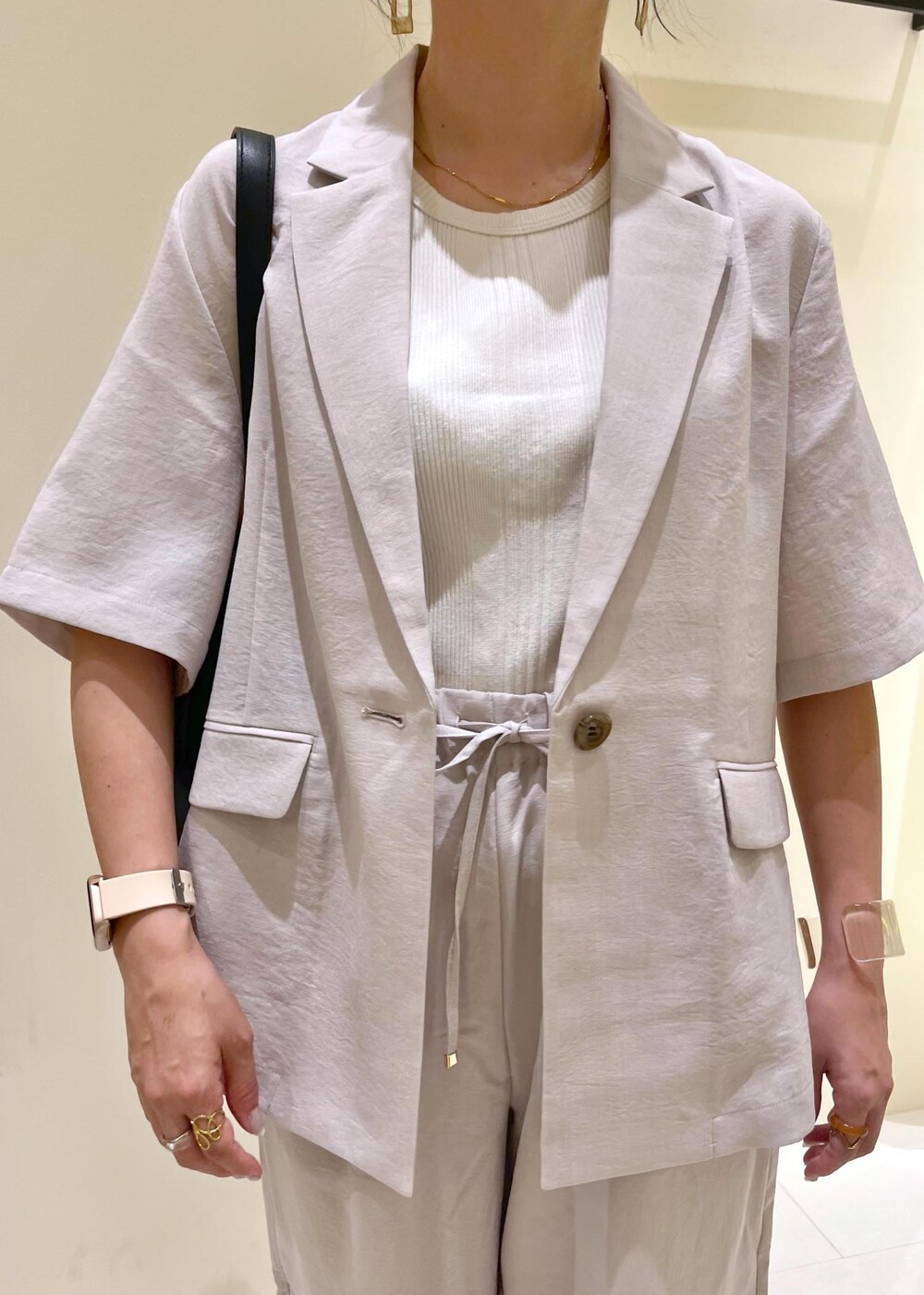 ベージュ系のタンクトップ、ベージュ系のその他パンツ、ベージュ系のテーラードジャケットを着用したレディースの夏コーディネートの6枚目の写真