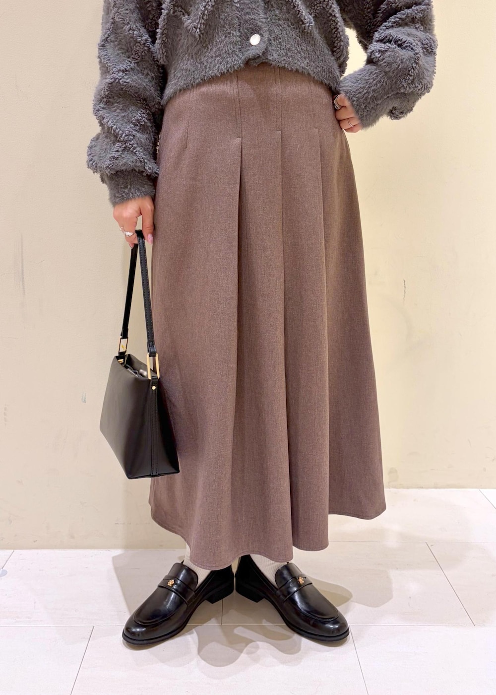 ベージュ系のスカート、グレー系のカーディガン/ボレロ、ホワイト系のTシャツ/カットソーを着用したレディースの冬コーディネートの8枚目の写真