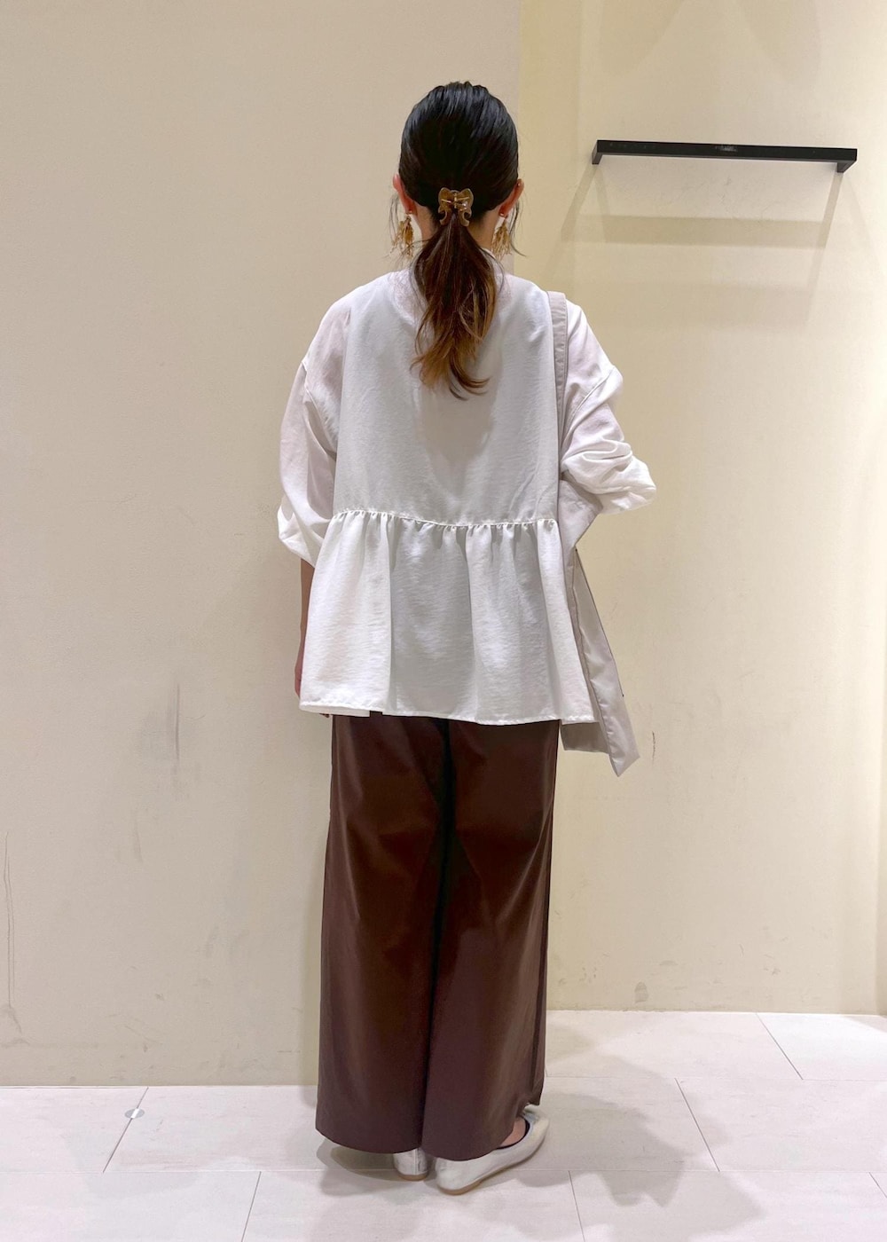 シルバー系のバレエシューズ、ブラウン系のその他パンツ、ホワイト系のシャツ/ブラウスを着用したレディースの秋コーディネートの3枚目の写真