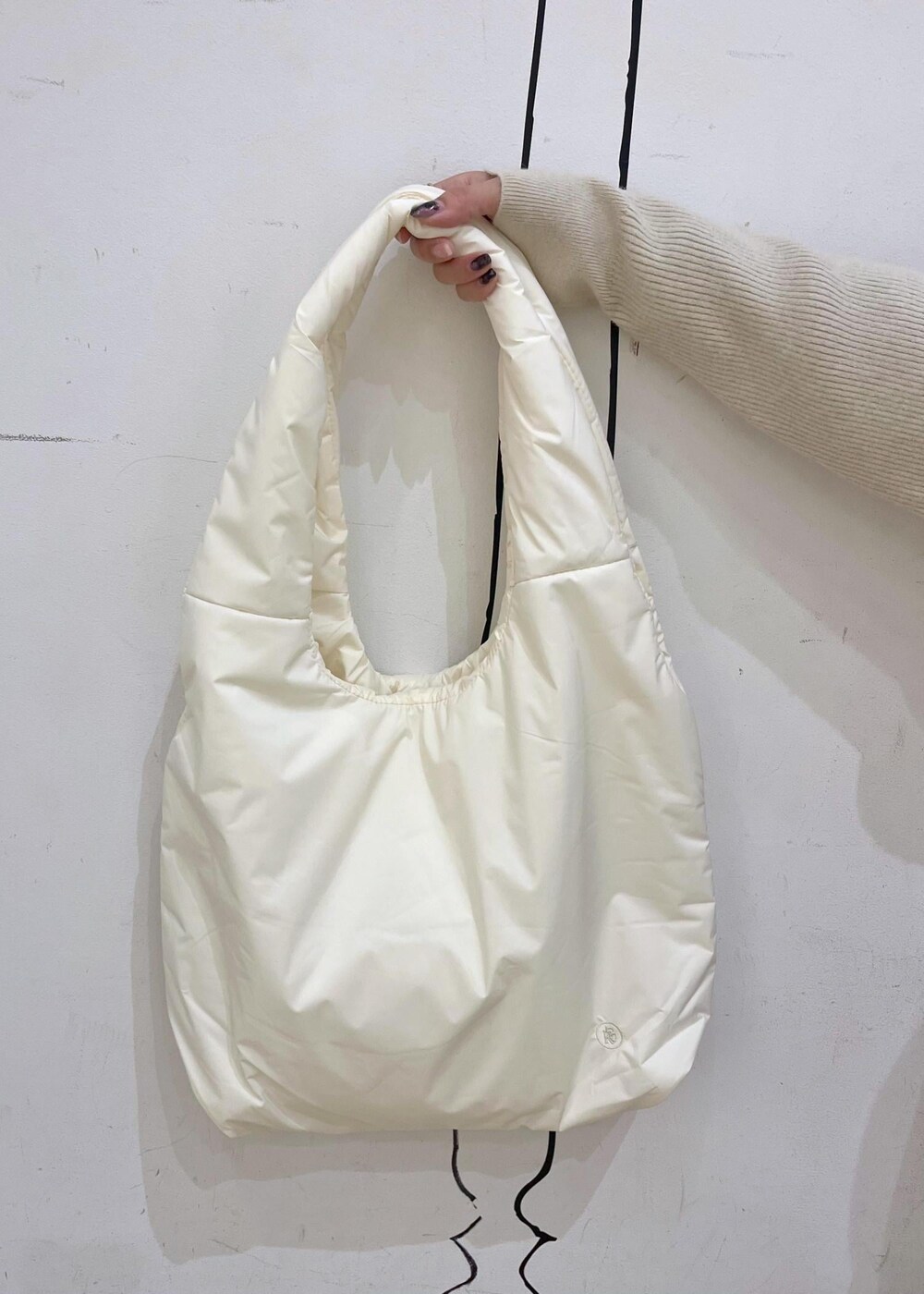 ベージュ系のニット/セーター、ホワイト系のトートバッグ、ブラック系のスリッポンを着用したレディースの冬コーディネートの8枚目の写真