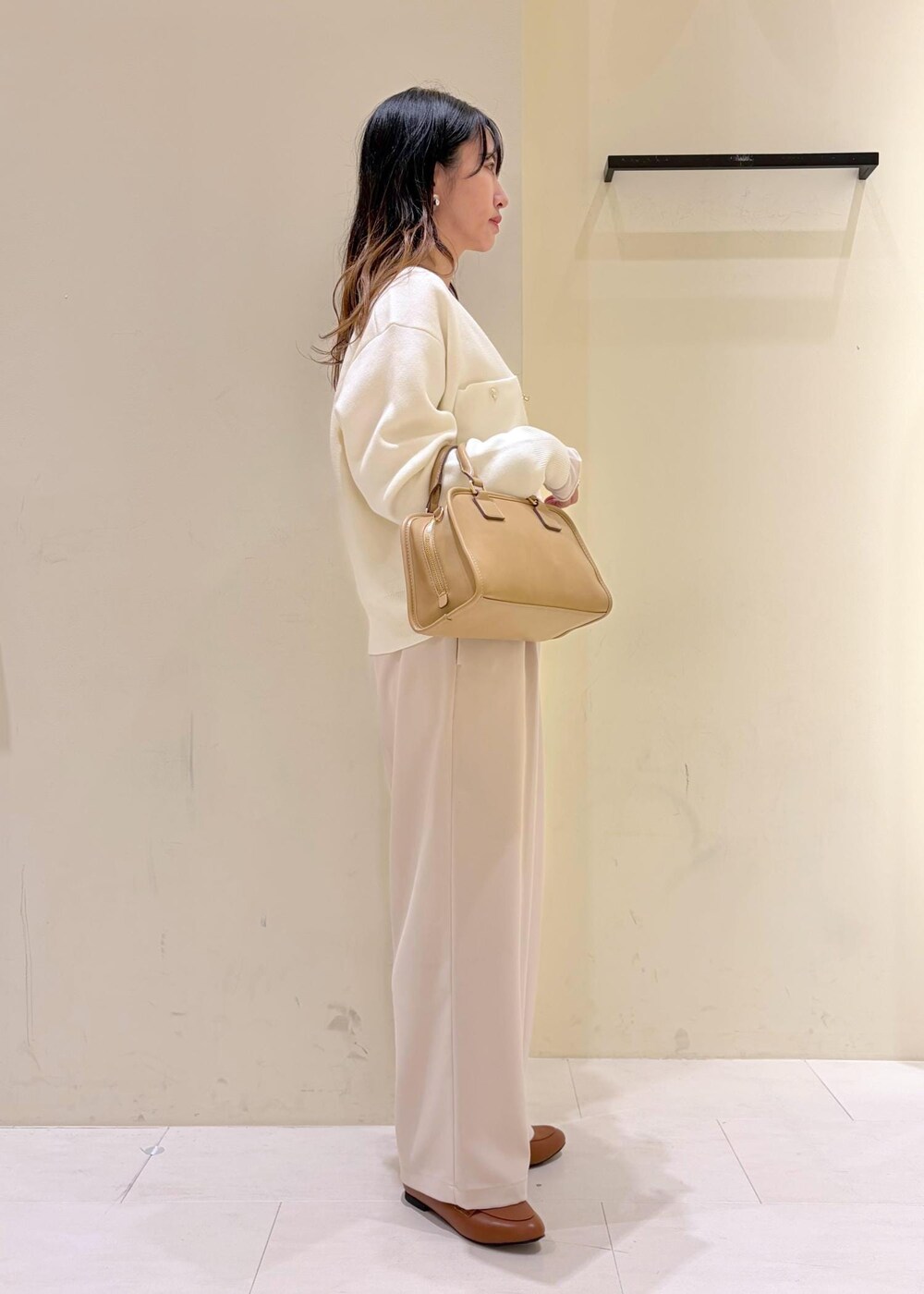 ホワイト系のTシャツ/カットソー、イエロー系のローファー、ベージュ系のボストンバッグを着用したレディースの冬コーディネートの3枚目の写真