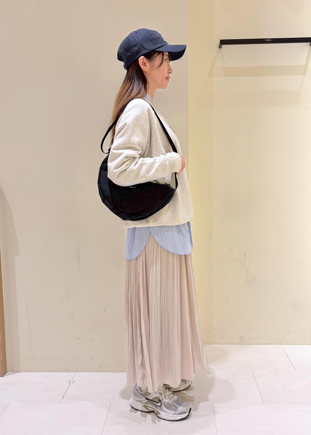 ホワイト系のスウェット、ブルー系のシャツ/ブラウス、ベージュ系のスカートを着用したレディースの冬コーディネートの2枚目の写真