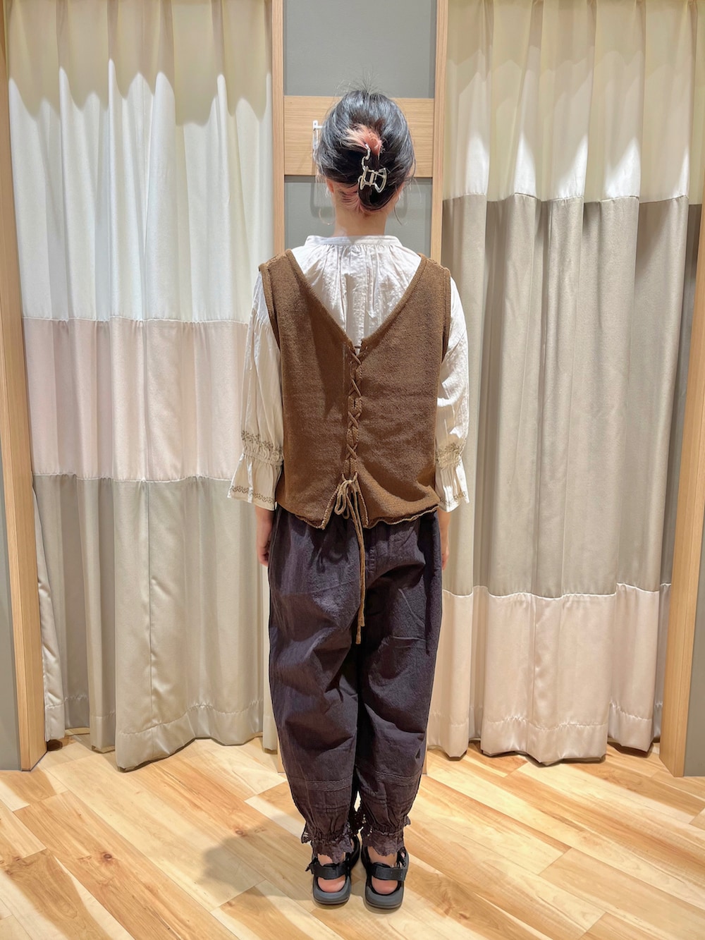 ブラウン系のベスト、ホワイト系のシャツ/ブラウス、ブラック系のその他パンツを着用したレディースの秋コーディネートの3枚目の写真