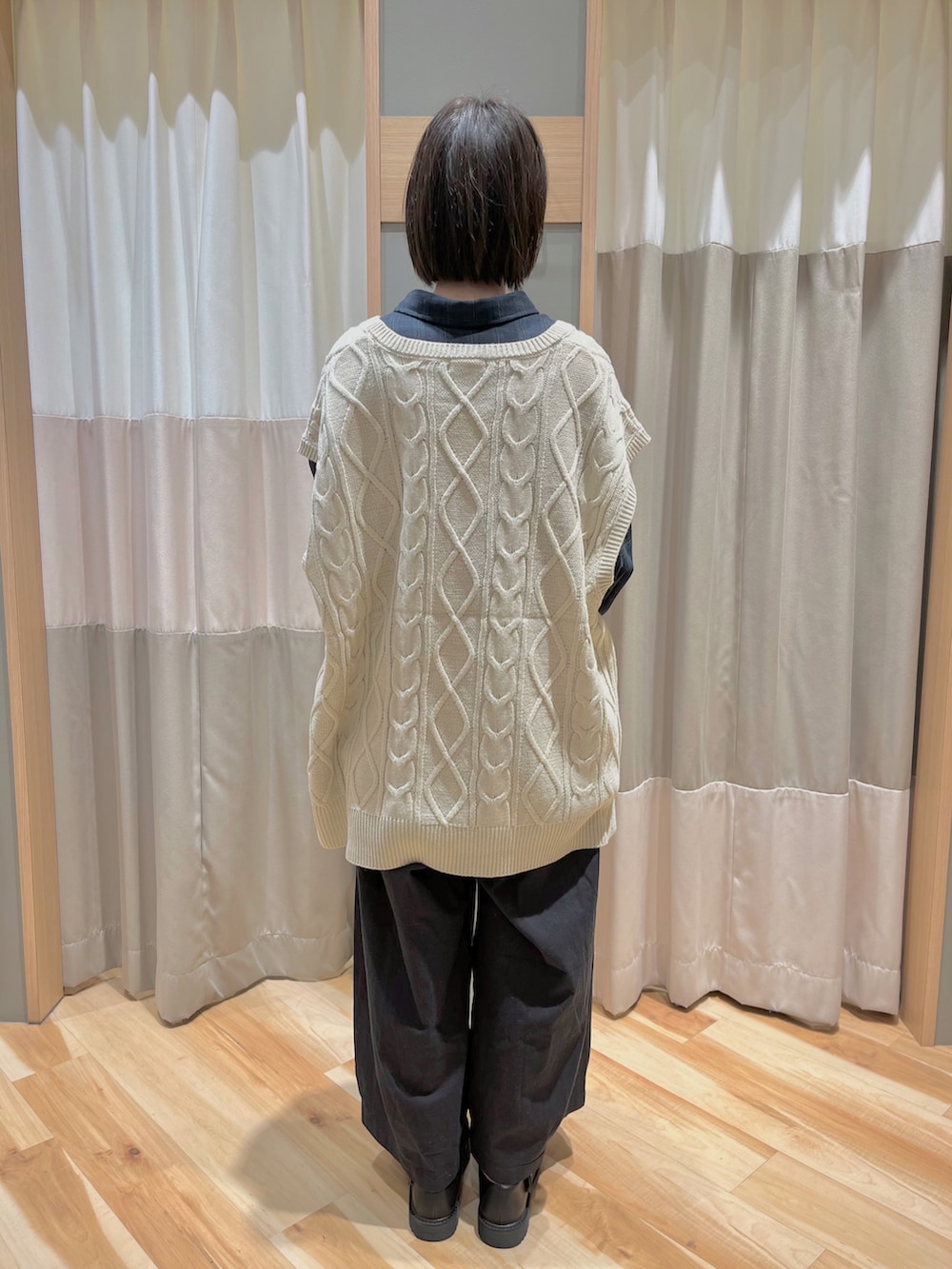 ホワイト系のベスト、ブルー系のシャツ/ブラウス、ブラック系のパンツを着用したレディースの冬コーディネートの4枚目の写真