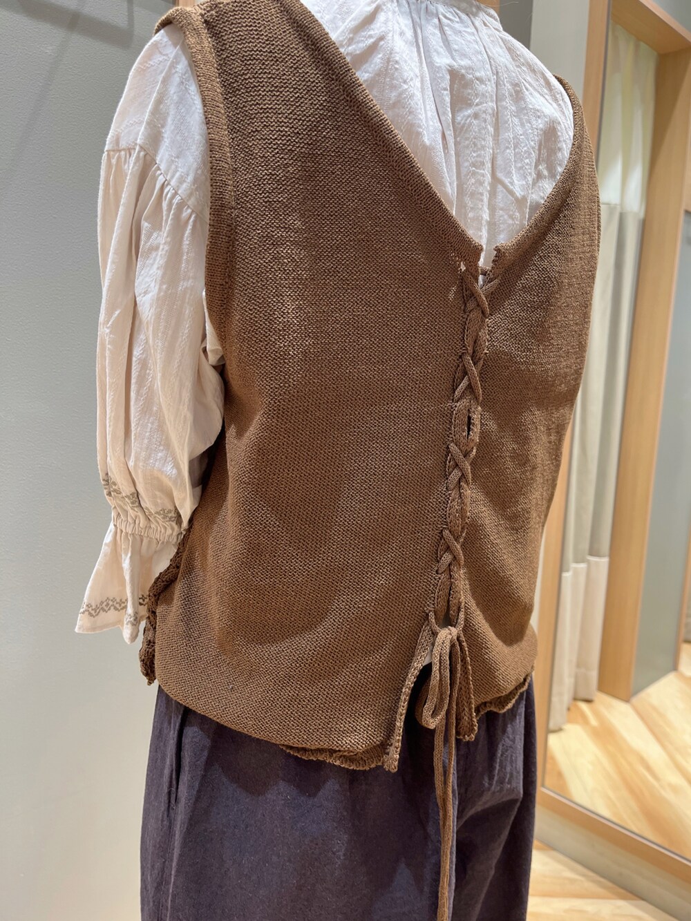 ブラウン系のベスト、ホワイト系のシャツ/ブラウス、ブラック系のその他パンツを着用したレディースの秋コーディネートの5枚目の写真