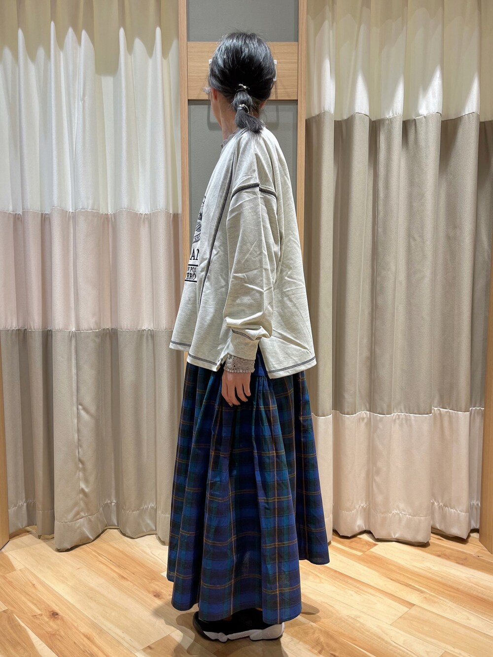 ホワイト系のTシャツ/カットソー、ブルー系のスカート、ベージュ系のTシャツ/カットソーを着用したレディースの秋コーディネートの4枚目の写真