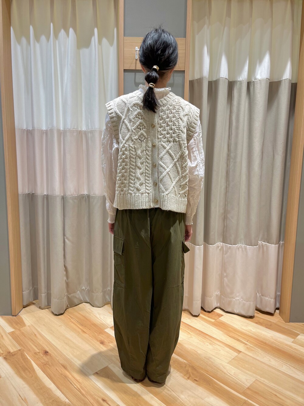 ホワイト系のベスト、ホワイト系のシャツ/ブラウス、グリーン系のカーゴパンツを着用したレディースの冬コーディネートの3枚目の写真