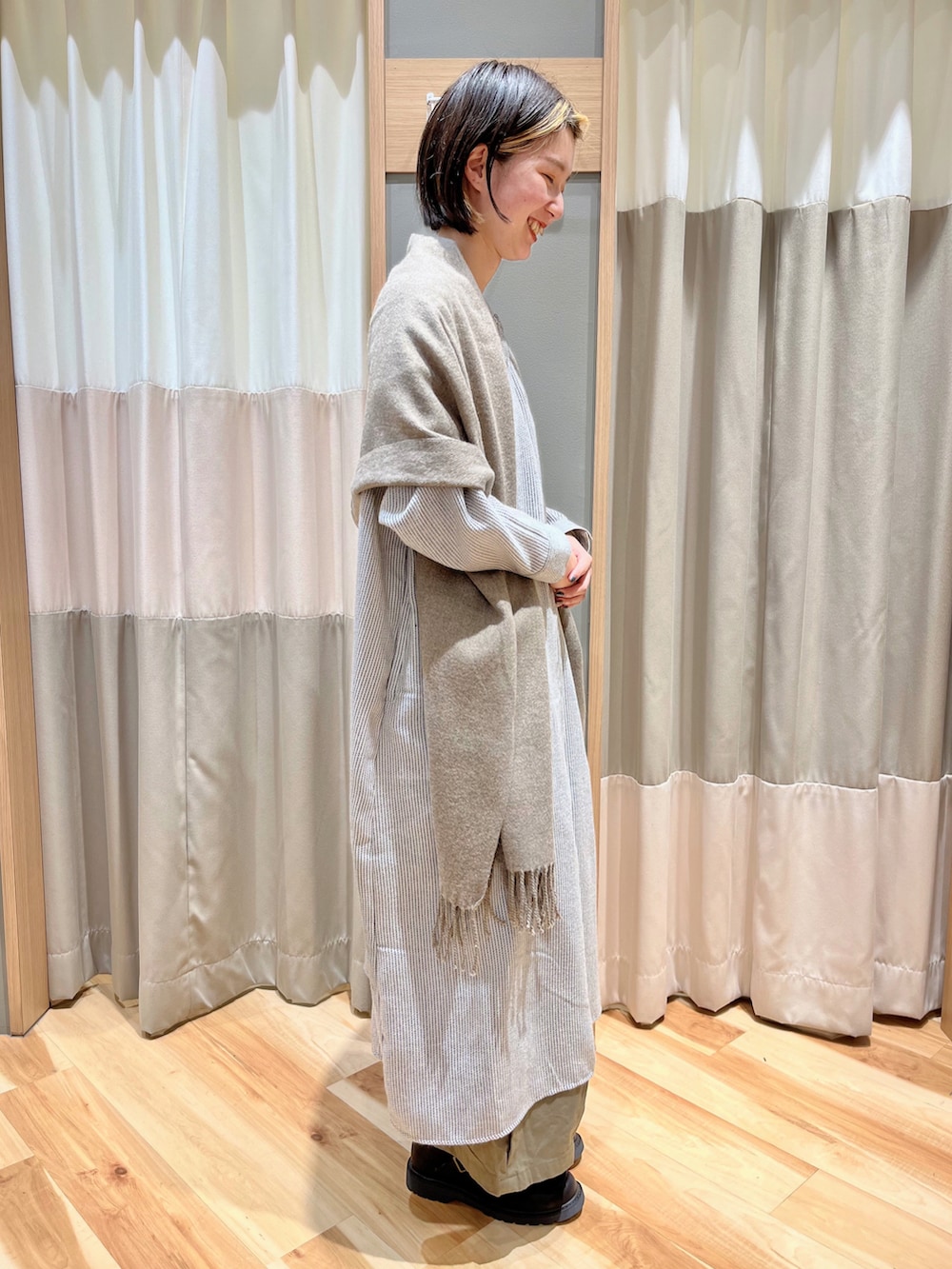 ブルー系のワンピース、グレー系のマフラーを着用したレディースの春コーディネートの2枚目の写真