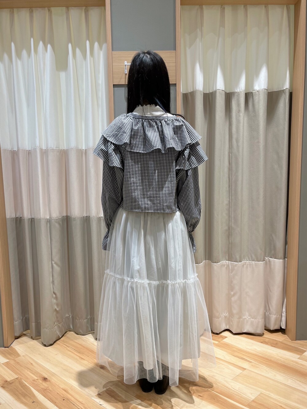 ブラック系のシャツ/ブラウス、ホワイト系のスカート、ブラック系のその他シューズを着用したレディースの冬コーディネートの3枚目の写真