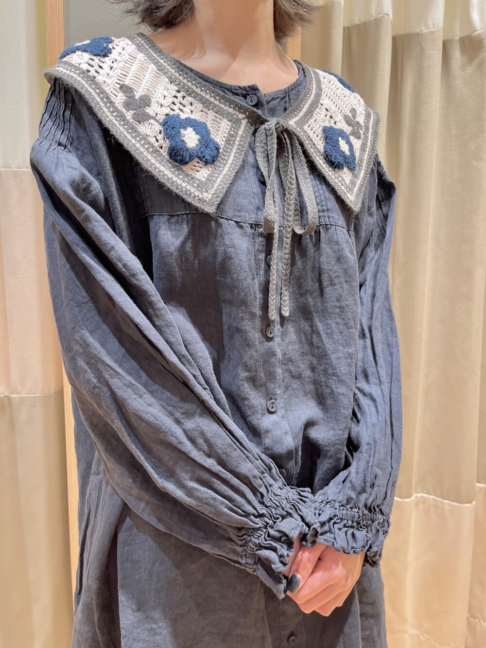 ブルー系のチュニック、ホワイト系のその他パンツ、ブラック系のドレスシューズを着用したレディースの春コーディネートの3枚目の写真