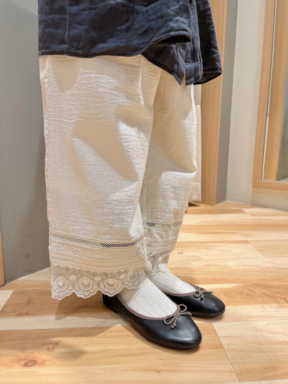 ブルー系のチュニック、ホワイト系のその他パンツ、ブラック系のドレスシューズを着用したレディースの春コーディネートの4枚目の写真