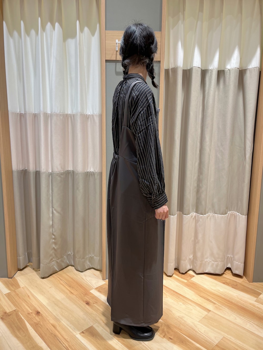 グレー系のサロペット/オーバーオール、ブラック系のシャツ/ブラウス、ブラック系のブーツを着用したレディースの冬コーディネートの3枚目の写真