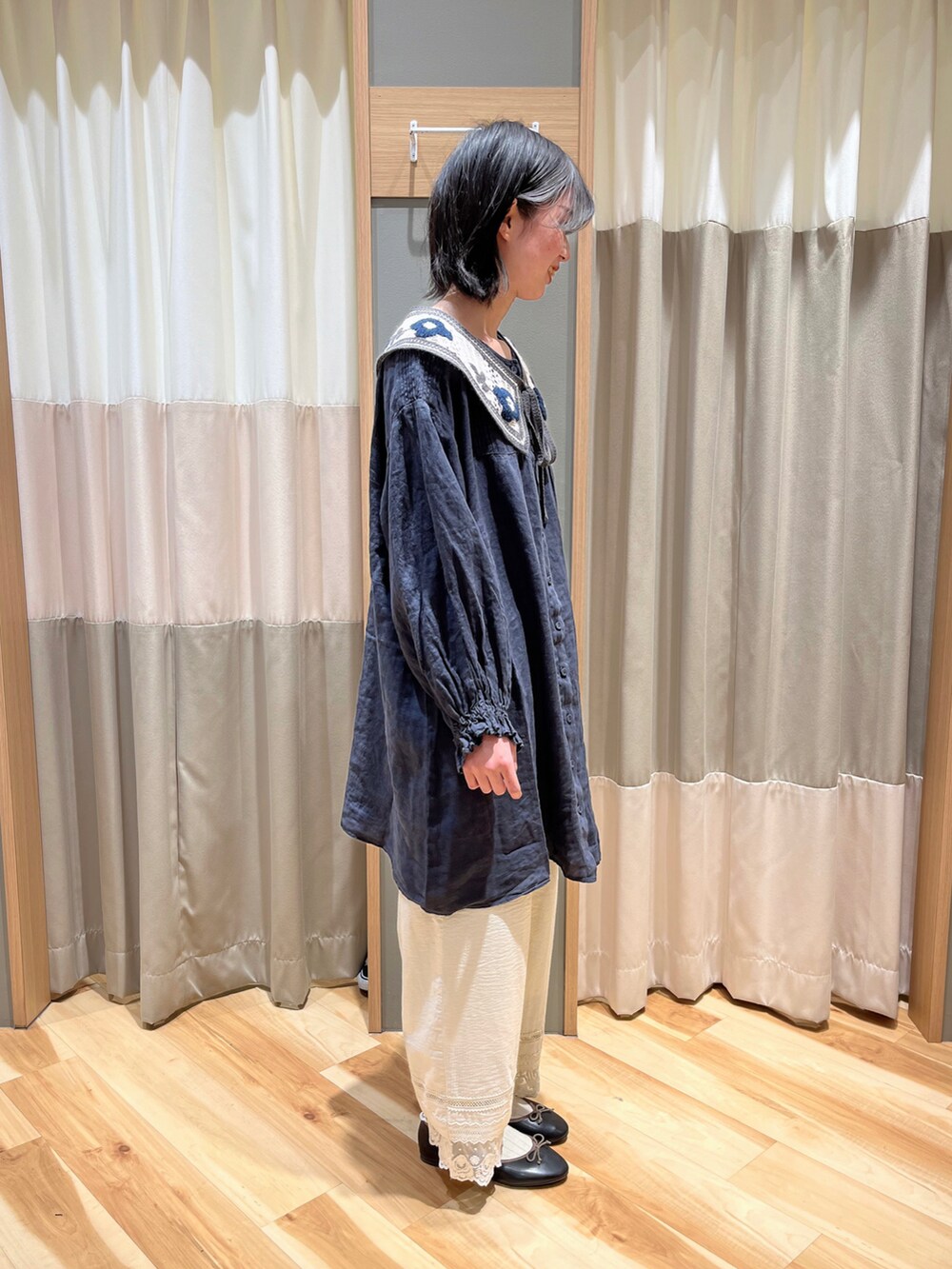 ブルー系のチュニック、ホワイト系のその他パンツ、ブラック系のドレスシューズを着用したレディースの春コーディネートの2枚目の写真