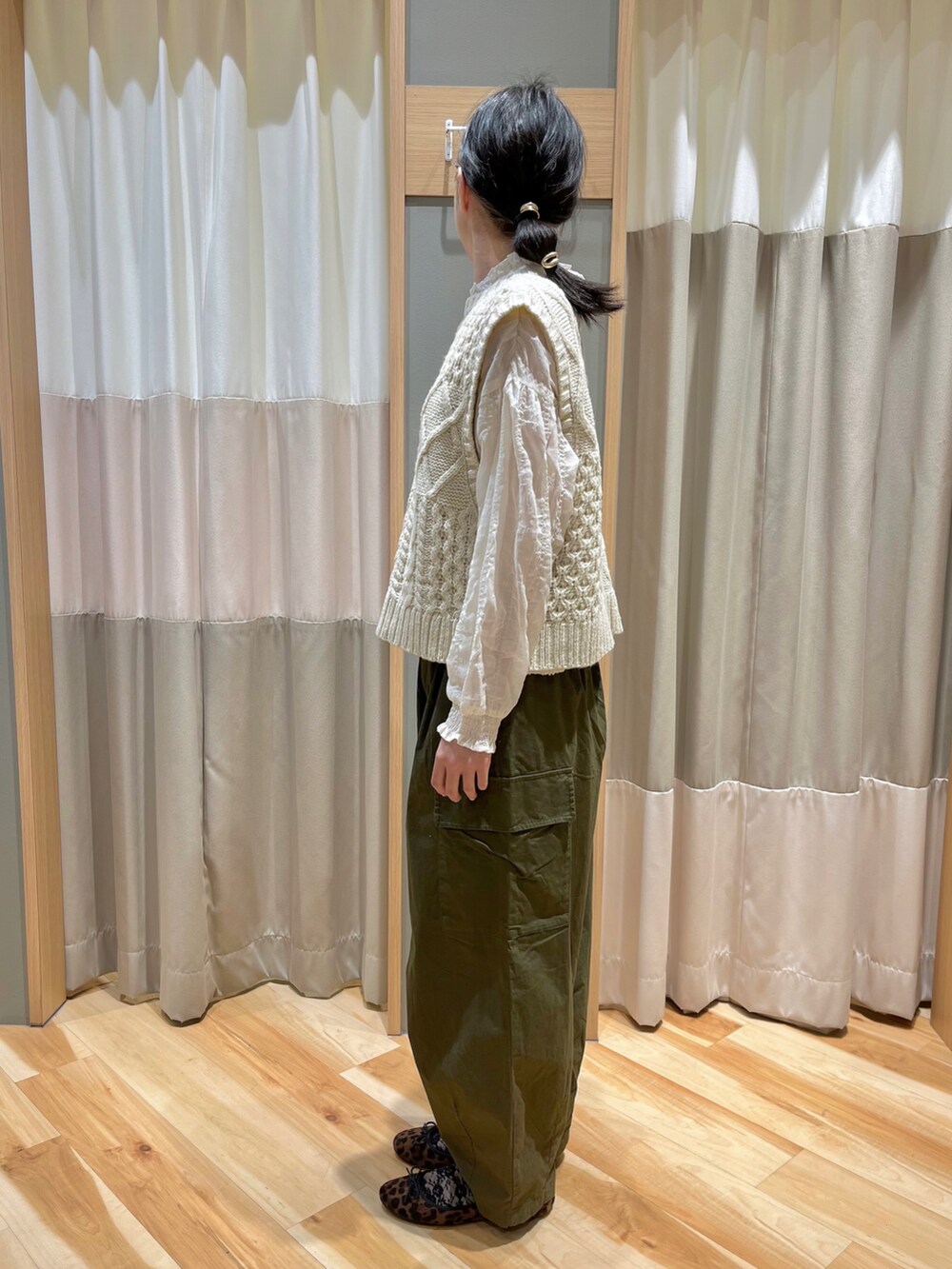 ホワイト系のベスト、ホワイト系のシャツ/ブラウス、グリーン系のカーゴパンツを着用したレディースの冬コーディネートの4枚目の写真