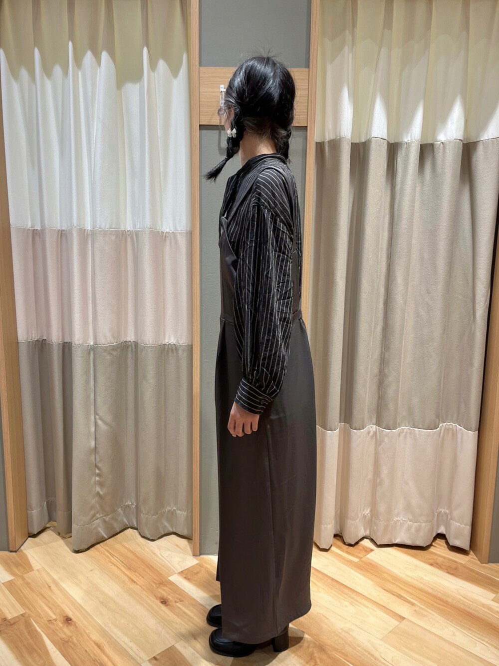 グレー系のサロペット/オーバーオール、ブラック系のシャツ/ブラウス、ブラック系のブーツを着用したレディースの冬コーディネートの4枚目の写真