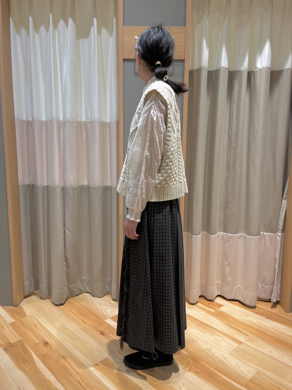 ホワイト系のベスト、ホワイト系のシャツ/ブラウス、グレー系のスカートを着用したレディースの冬コーディネートの4枚目の写真