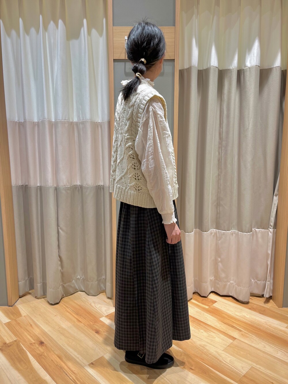 ホワイト系のベスト、ホワイト系のシャツ/ブラウス、グレー系のスカートを着用したレディースの冬コーディネートの2枚目の写真