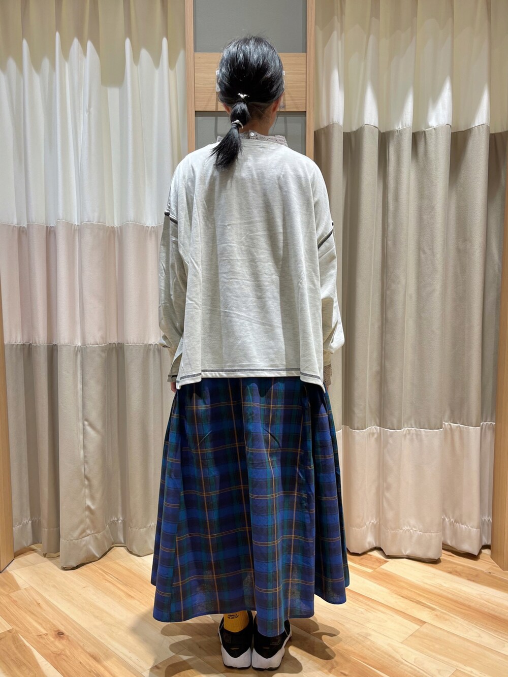 ホワイト系のTシャツ/カットソー、ブルー系のスカート、ベージュ系のTシャツ/カットソーを着用したレディースの秋コーディネートの3枚目の写真