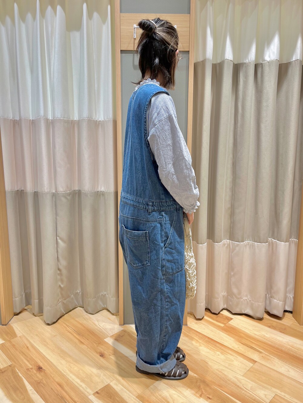 ブルー系のサロペット/オーバーオール、ブルー系のシャツ/ブラウス、ホワイト系のハンドバッグを着用したレディースの春コーディネートの2枚目の写真