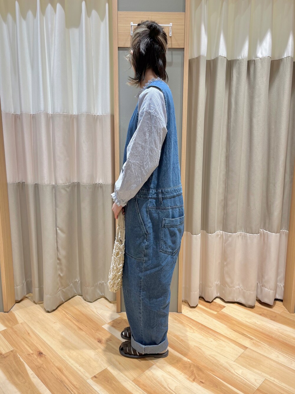 ブルー系のサロペット/オーバーオール、ブルー系のシャツ/ブラウス、ホワイト系のハンドバッグを着用したレディースの春コーディネートの4枚目の写真