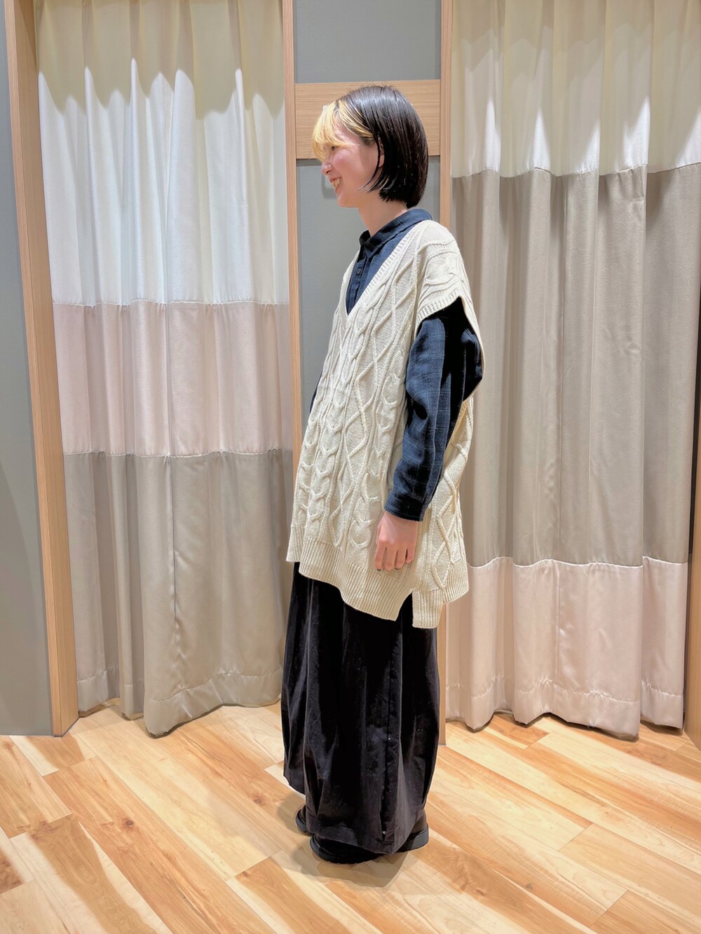 ホワイト系のベスト、ブルー系のシャツ/ブラウス、ブラック系のパンツを着用したレディースの冬コーディネートの3枚目の写真