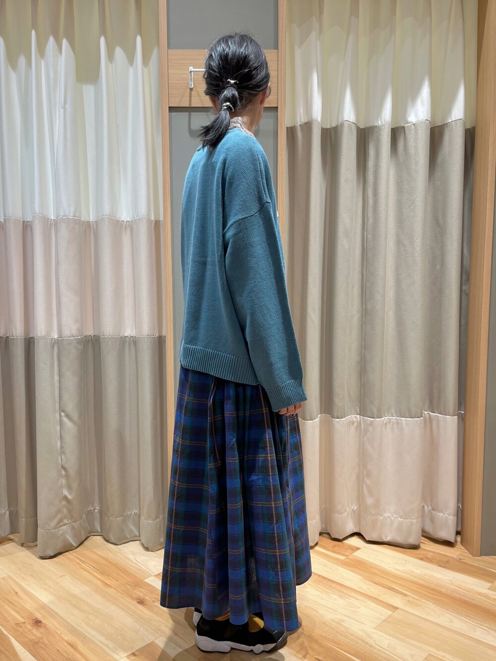 ブルー系のニット/セーター、ベージュ系のTシャツ/カットソー、ブルー系のスカートを着用したレディースの秋コーディネートの2枚目の写真