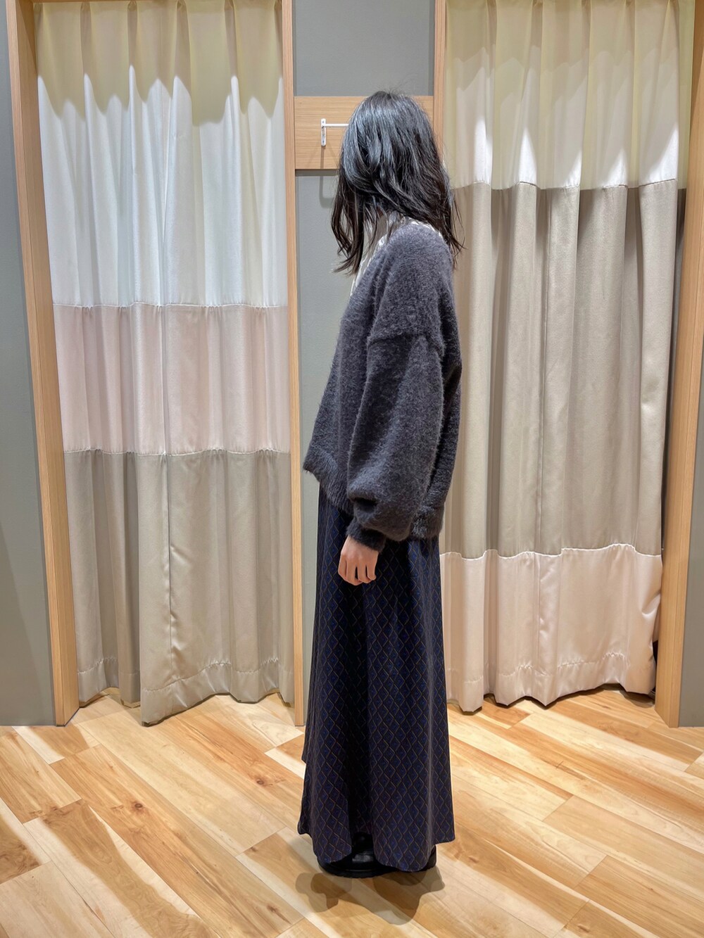 グレー系のカーディガン/ボレロ、ブルー系のスカート、ホワイト系のシャツ/ブラウスを着用したレディースの冬コーディネートの4枚目の写真