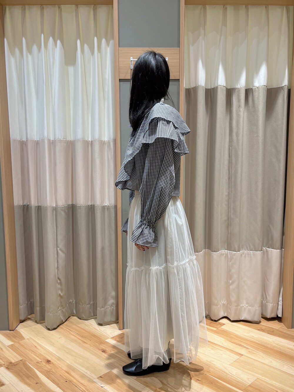 ブラック系のシャツ/ブラウス、ホワイト系のスカート、ブラック系のその他シューズを着用したレディースの冬コーディネートの4枚目の写真