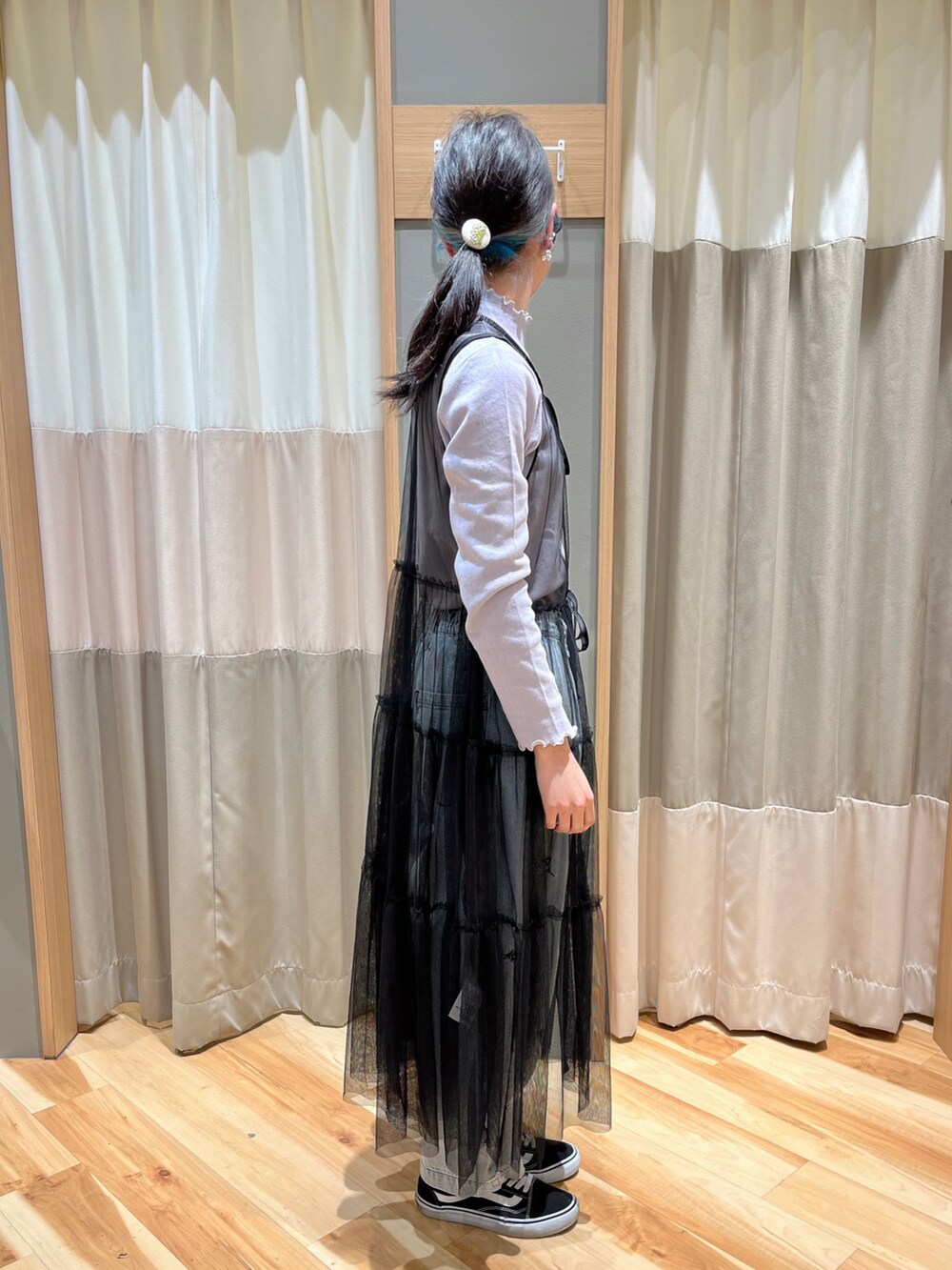 ブラック系のワンピース、パープル系のTシャツ/カットソー、ブルー系のデニムパンツを着用したレディースの春コーディネートの2枚目の写真