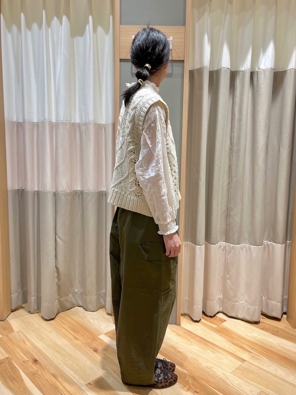 ホワイト系のベスト、ホワイト系のシャツ/ブラウス、グリーン系のカーゴパンツを着用したレディースの冬コーディネートの2枚目の写真