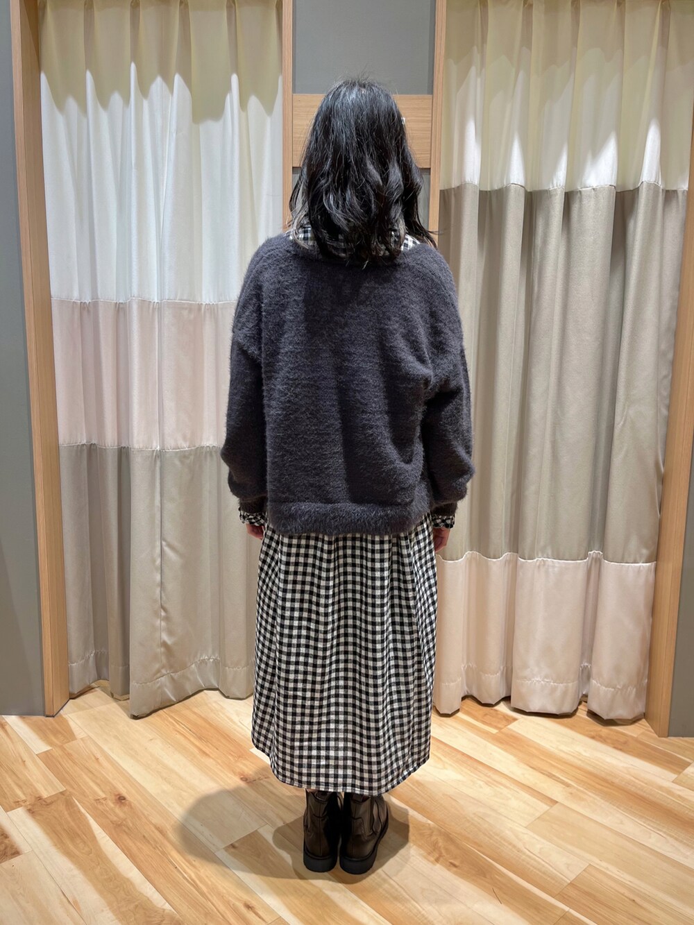 ブラック系のワンピース、グレー系のカーディガン/ボレロ、ブラック系のブーツを着用したレディースの冬コーディネートの3枚目の写真