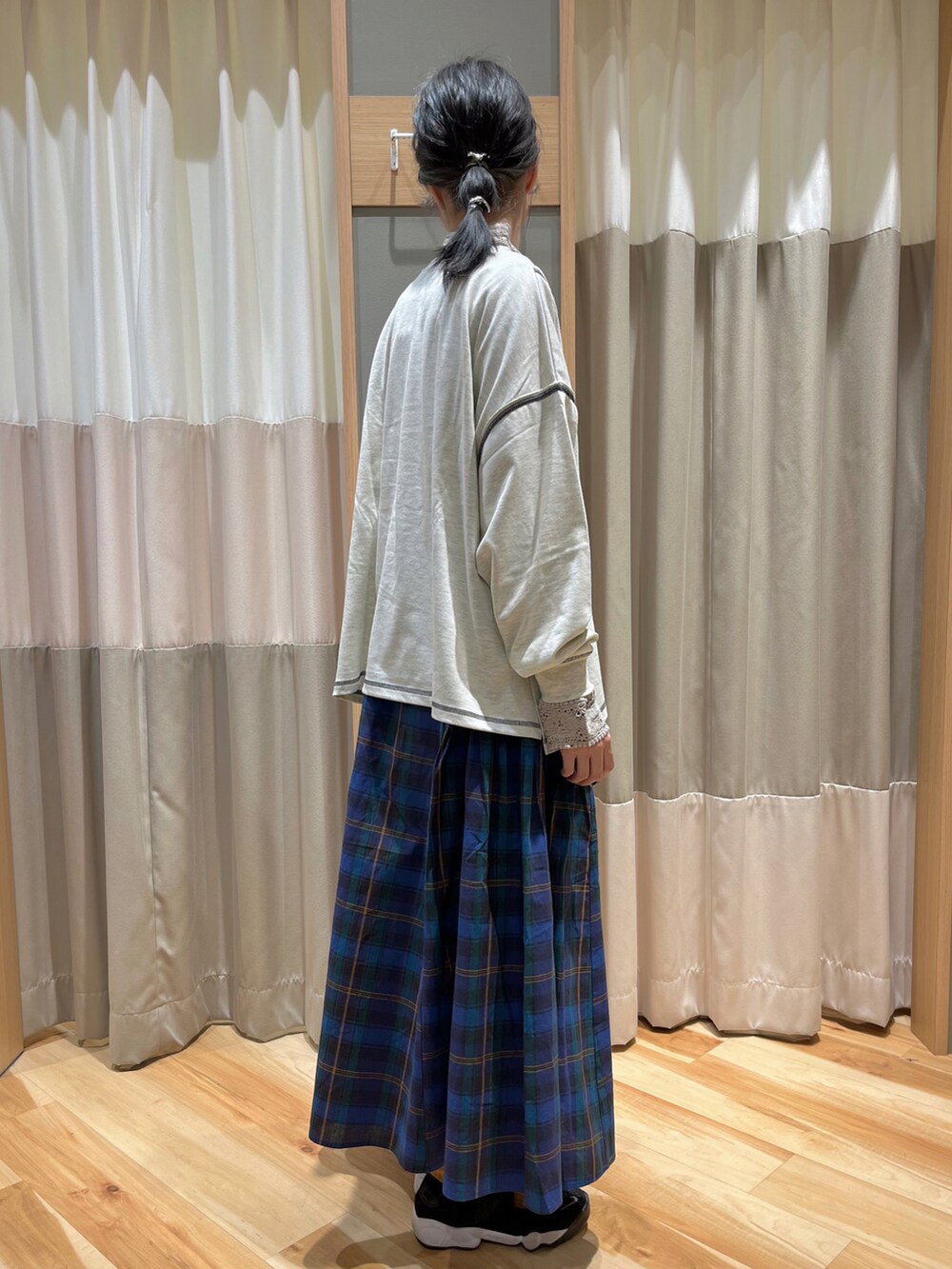 ホワイト系のTシャツ/カットソー、ブルー系のスカート、ベージュ系のTシャツ/カットソーを着用したレディースの秋コーディネートの2枚目の写真