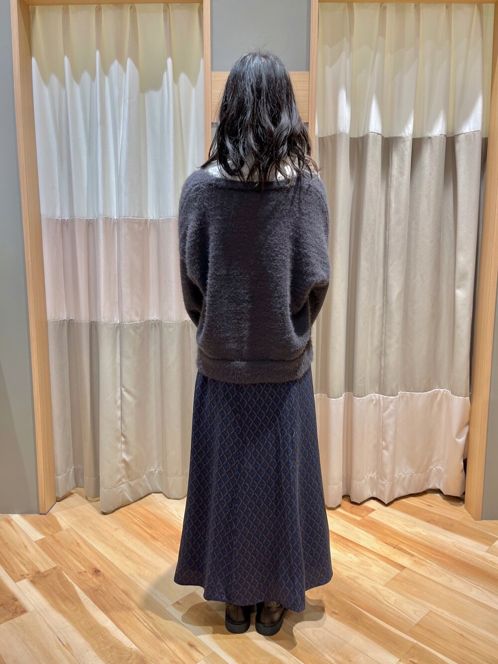 グレー系のカーディガン/ボレロ、ブルー系のスカート、ホワイト系のシャツ/ブラウスを着用したレディースの冬コーディネートの3枚目の写真