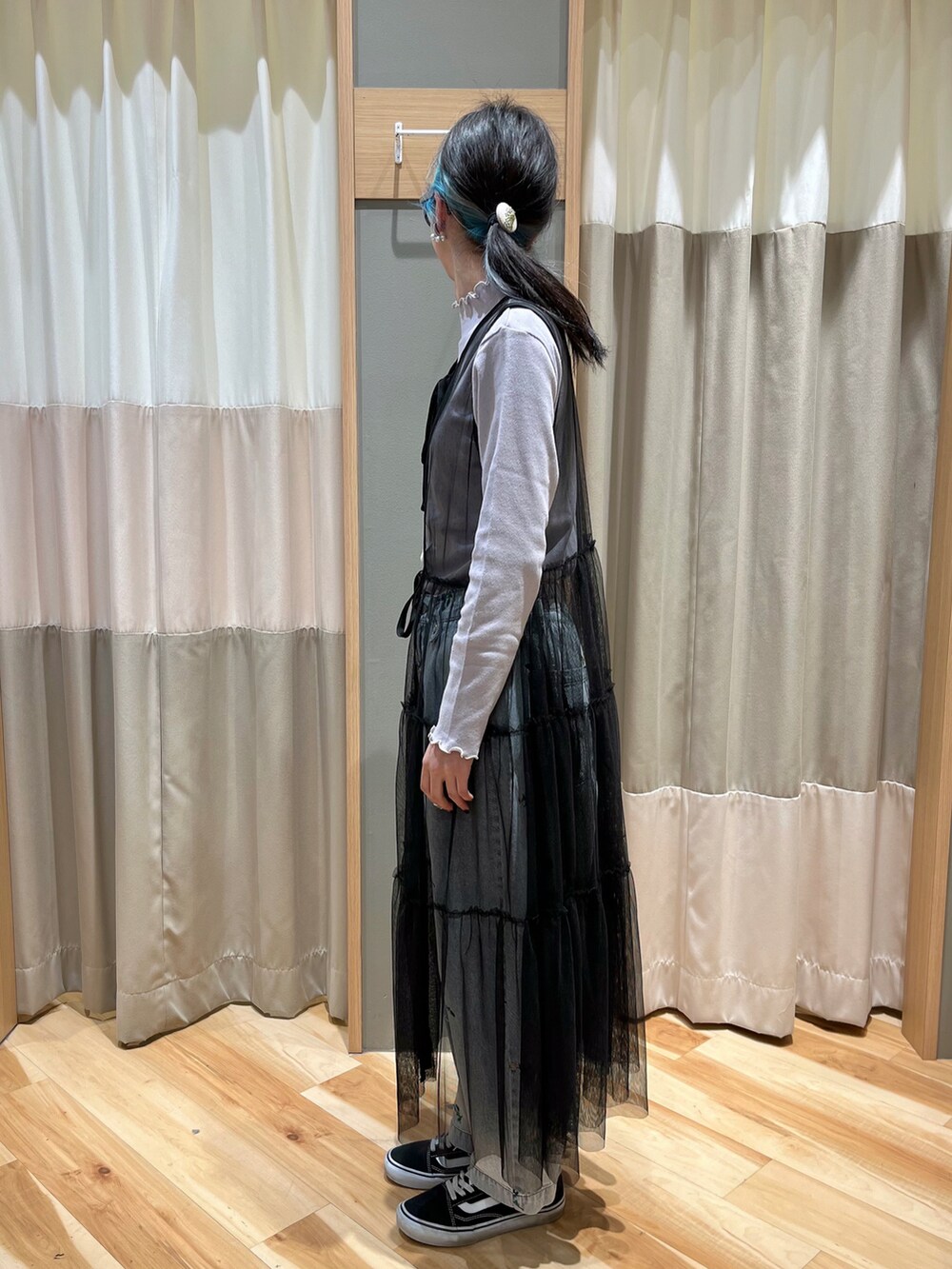 ブラック系のワンピース、パープル系のTシャツ/カットソー、ブルー系のデニムパンツを着用したレディースの春コーディネートの4枚目の写真