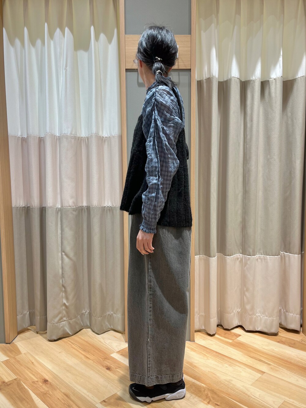 ブラック系のニット/セーター、ブルー系のシャツ/ブラウス、グレー系のデニムパンツを着用したレディースの秋コーディネートの4枚目の写真