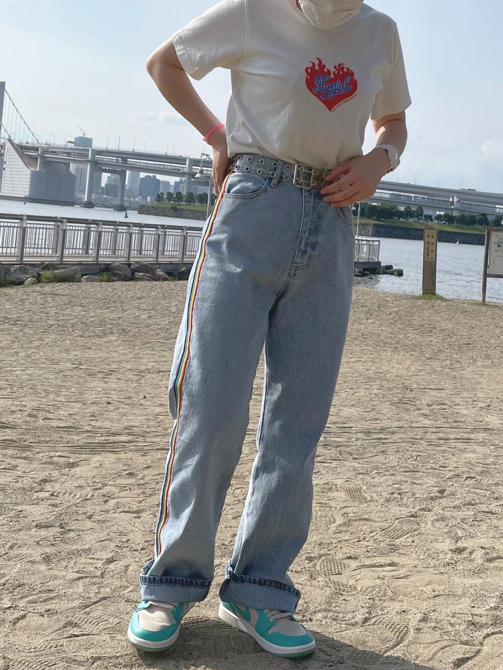 ブルー系のデニムパンツ、グリーン系のスニーカー、ホワイト系のTシャツ/カットソーを着用したレディースの夏コーディネートの2枚目の写真