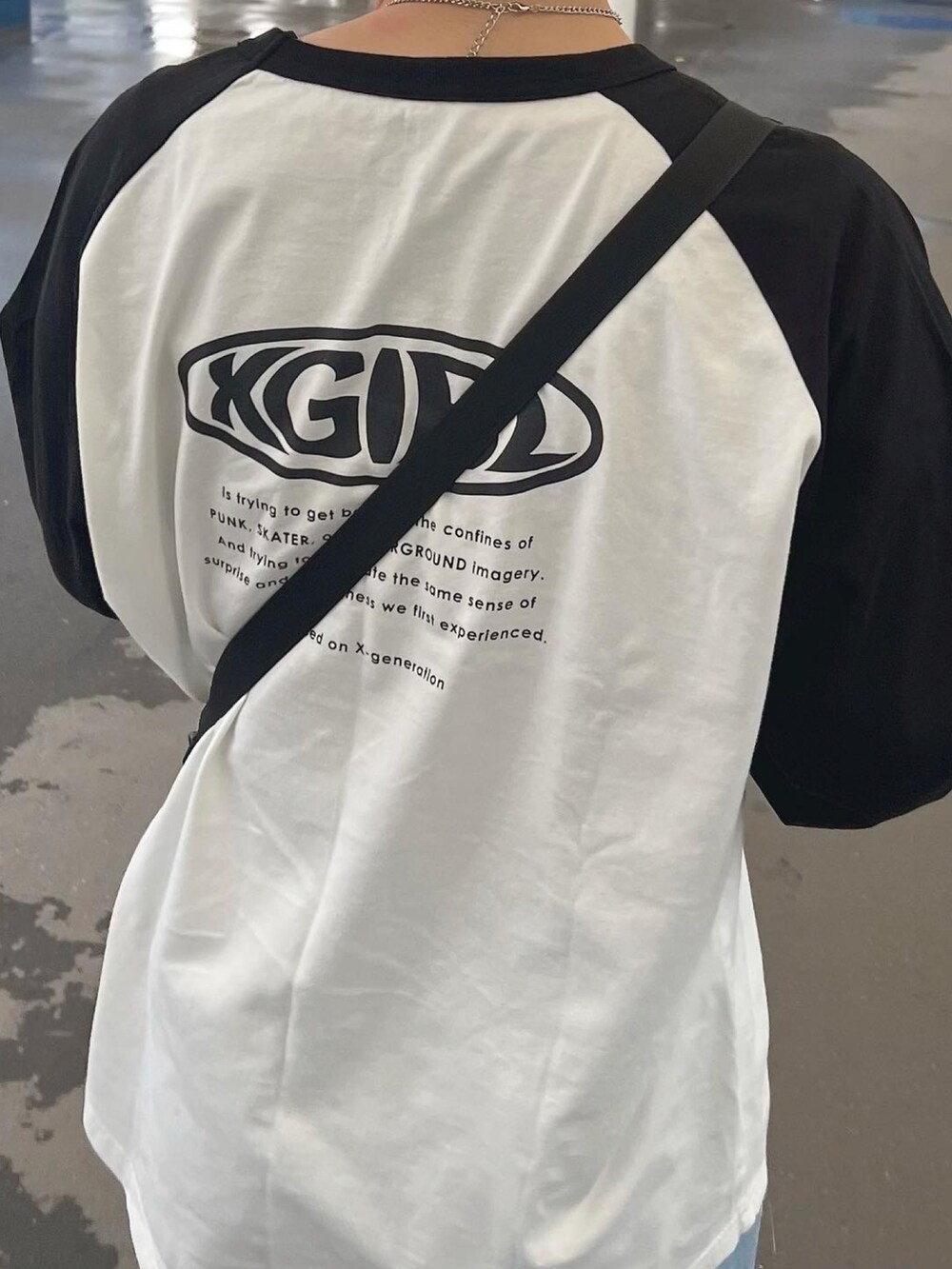 ホワイト系のTシャツ/カットソー、ブラック系のショルダーバッグ、ホワイト系のスリッポンを着用したレディースの秋コーディネートの2枚目の写真