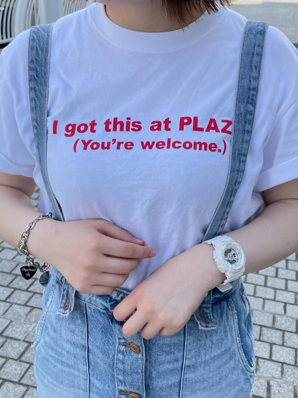 ホワイト系のトップス、ブルー系のオールインワン・サロペット、レッド系のスニーカーを着用したレディースの春コーディネートの2枚目の写真