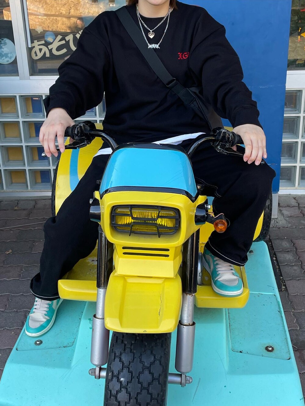 ブラック系のスウェット、ブラック系のデニムパンツ、グリーン系のスニーカーを着用したレディースの秋コーディネートの2枚目の写真