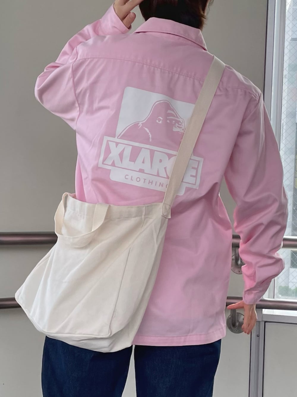 ピンク系のシャツ/ブラウス、ブルー系のデニムパンツ、ピンク系のスニーカーを着用したレディースの夏コーディネートの2枚目の写真