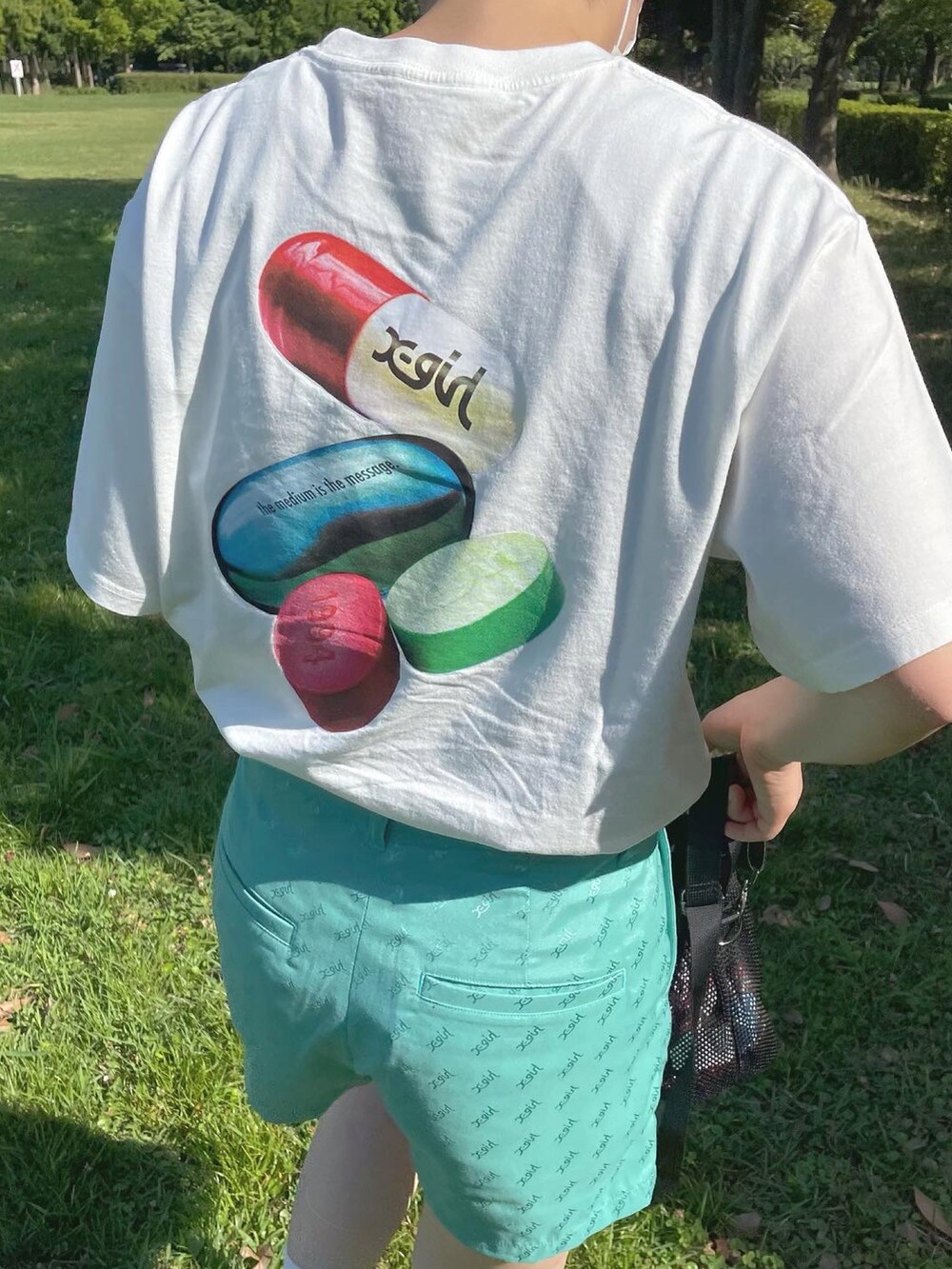 ホワイト系のTシャツ/カットソー、ブラック系のショルダーバッグ、グリーン系のその他パンツを着用したレディースの夏コーディネートの2枚目の写真