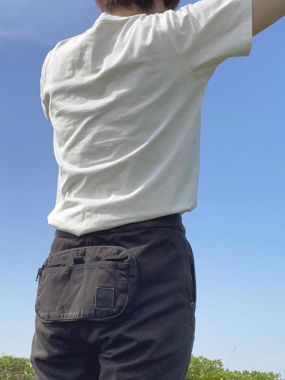 ブラック系のその他パンツ、ホワイト系のTシャツ/カットソー、ホワイト系のスニーカーを着用したレディースの夏コーディネートの3枚目の写真